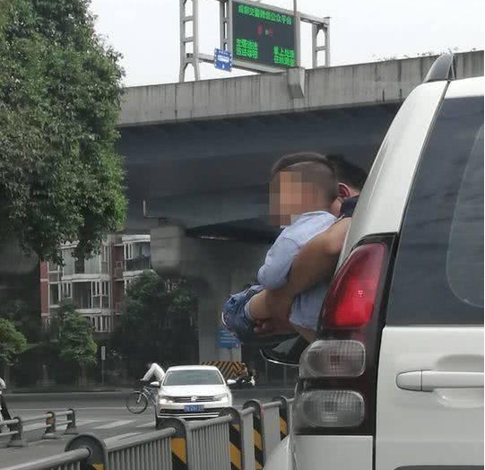 公路上小男孩尿急 父亲将其抱出窗外撒尿
