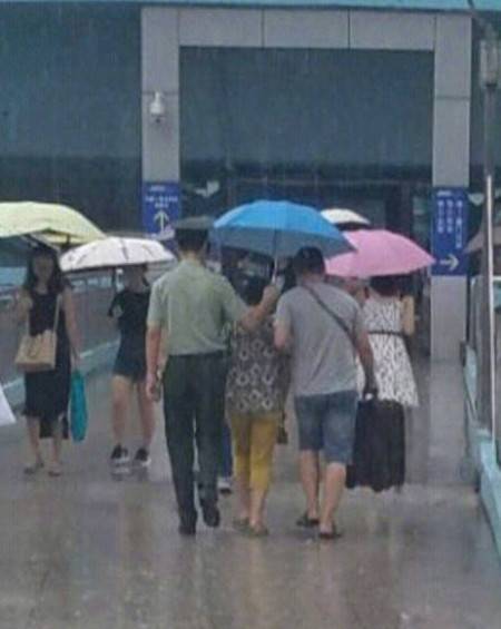 厦门火车站的一幕触动内心:士兵撑伞护送老人 自己却在暴雨中淋湿