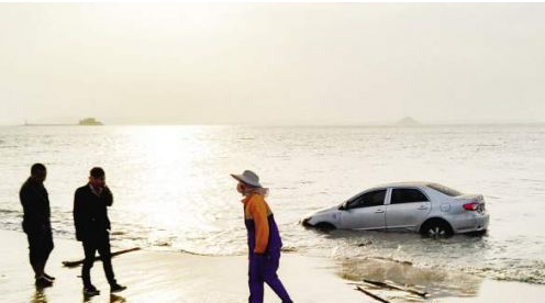 心大男子沙滩观海 涨潮后眼看豪车被淹没